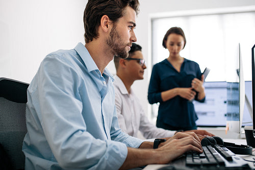 Application developers working on computers in office