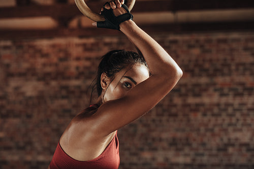 Strong woman exercising with dip rings