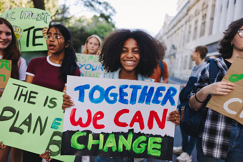 Cheerful young girl holding a poster during a climate strike