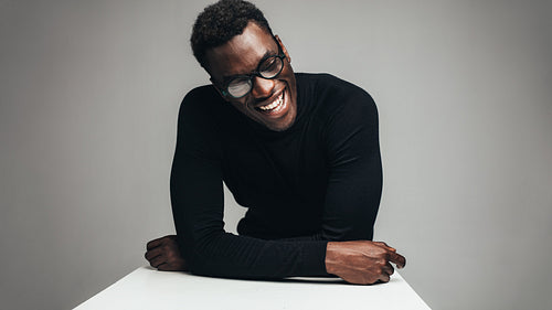 Cheerful african man sitting at table