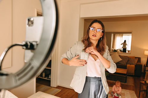 Freelance designer holding a fabric swatch  while recording a vi