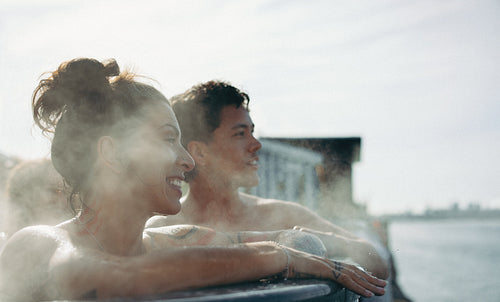 Friends enjoying spa wellness in outdoor hot tub with steam