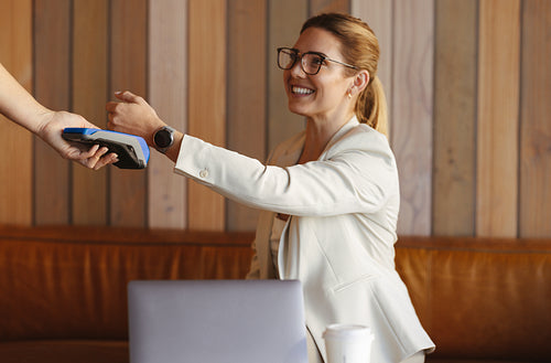 Woman making a payment using a smartwatch in a cafe