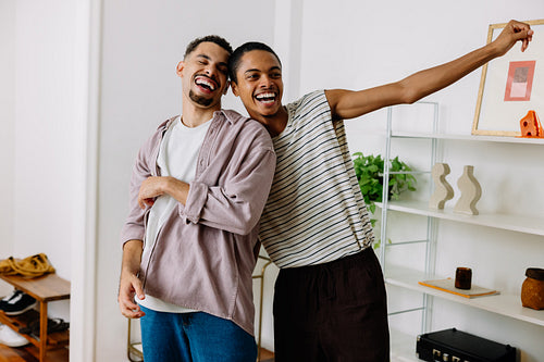 Happy friends laughing together in a stylish and cozy home environment