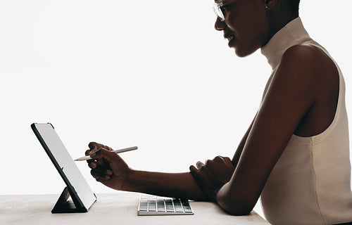 Professional woman using a digital tablet and stylus at a desk