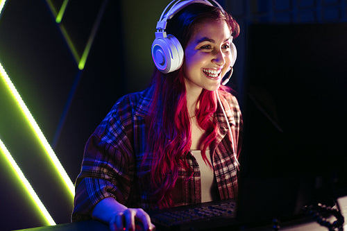 Female gamer smiling at her screen as she dominates a virtual game