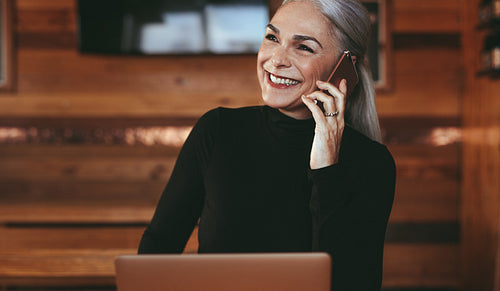 Senior businesswoman at coffee shop making a phone call