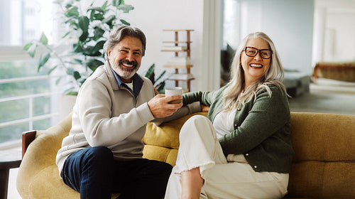 Senior couple relax together on a sofa at home