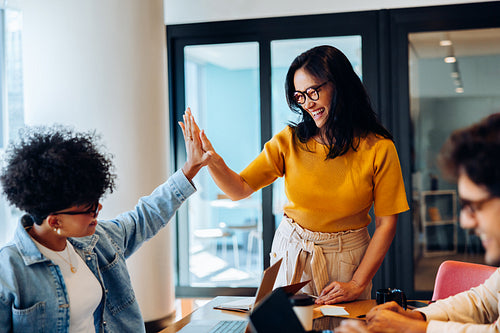 Celebrating progress: Teammates sharing a high-five