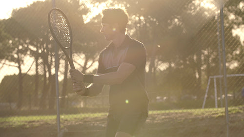 Male tennis player in action on hard court