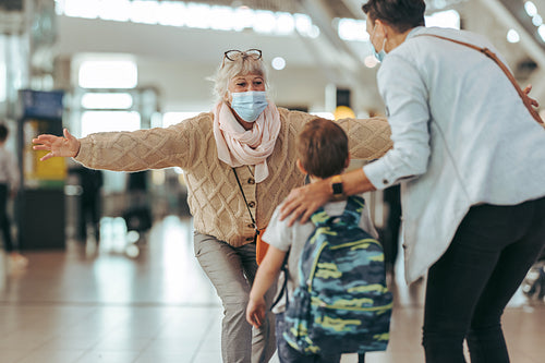 Senior woman welcoming her daughter and grandchild at airport