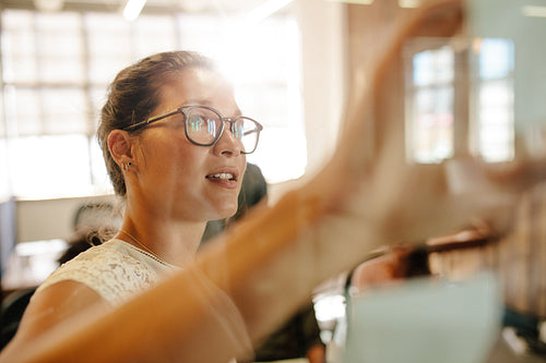 Business people meeting in office discussing over sticky notes