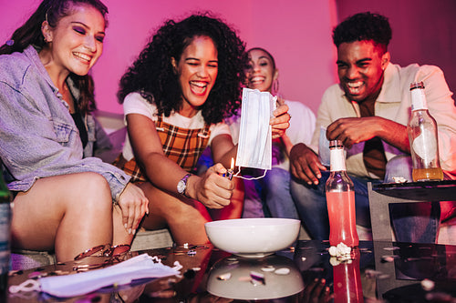Young woman burning a face mask at a post-pandemic party