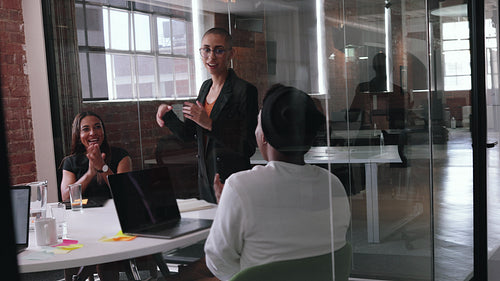 Successful business woman receiving an applause for her work in a team project