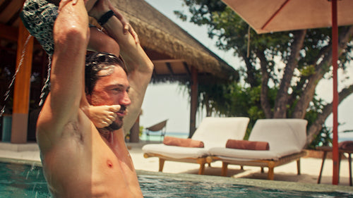 Happy family enjoys fun and laughter together while playing in a swimming pool