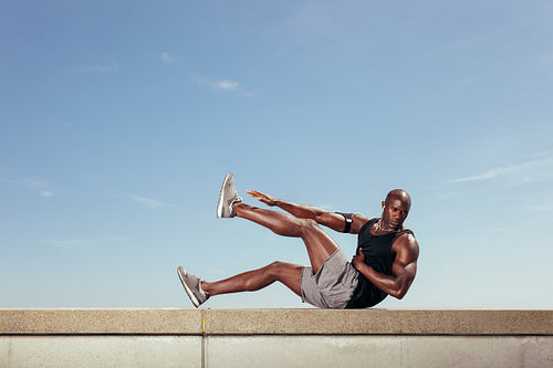 Fit young guy doing stretching workout 