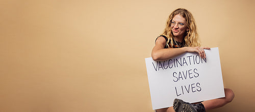 Woman with "Vaccination saves lives" banner