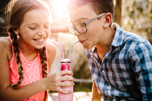 Kids drinking smoothie together