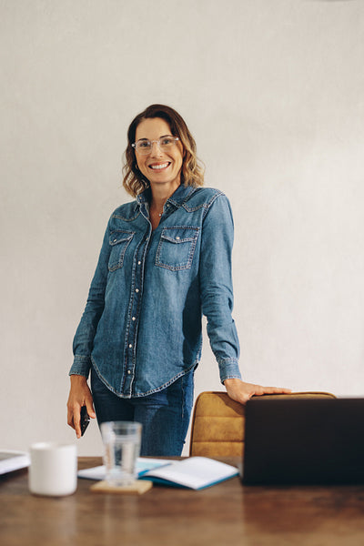Successful businesswoman standing in her office, dressed in denim
