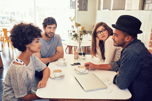 Young men and women sitting at a cafe