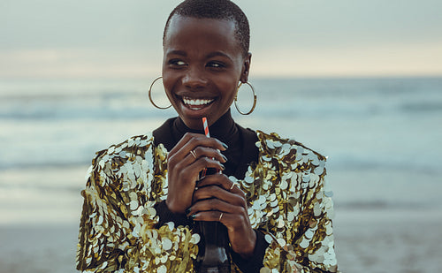 Beautiful woman having soft drink at beach