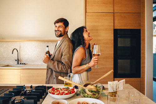 Couple enjoying a joyful moment while cooking together in a modern kitchen