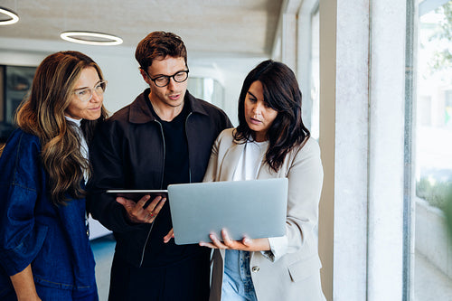 Three colleagues review business ideas together