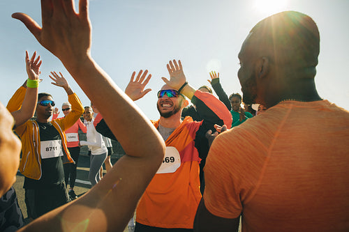 Group of runners celebrating with high fives after event