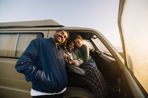 Friends enjoy a sunny road trip inside a van with smiles and warmth
