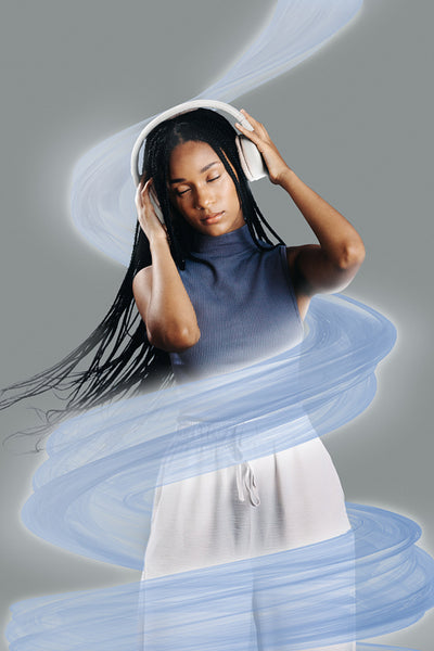 Black girl with braids vibing to music in a studio