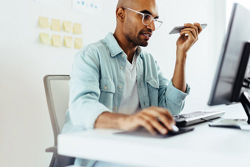 Software developer speaking to a client on the phone in an office