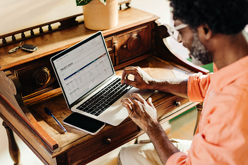 Focused Brazilian freelancer working on project at home office with laptop