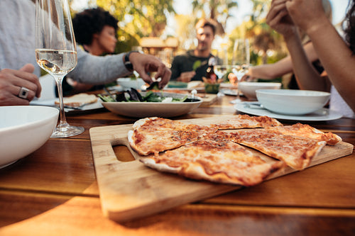Pizza on dining table with friends 