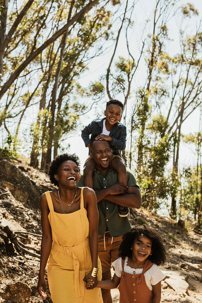 Family walking down mountain trail and smiling