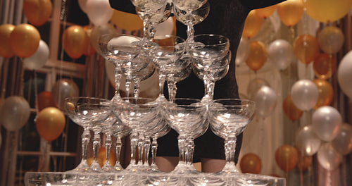 Woman pouring champagne into a pyramid of glasses