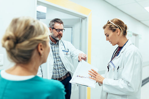 Medical staff having discussion in hospital corridor