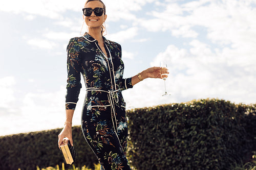 Stylish woman walking with glass of wine