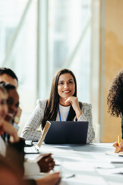 Confident female professional leading a vibrant marketing group discussion in a modern office setting with diverse participants engaged in collaborative strategies and ideas.
