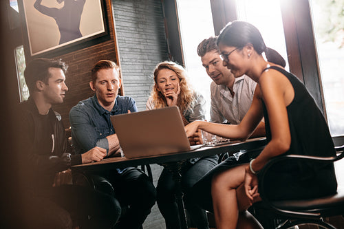 Friends in coffee shop using laptop