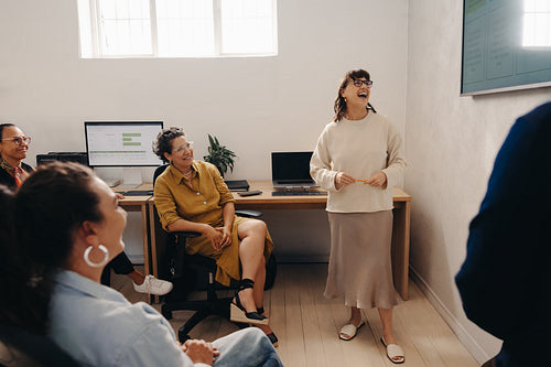 Happy team members enjoying a presentation in a bright modern office setting