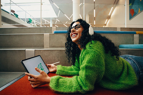 Study space in the public library inspires the woman to sketch on her tablet