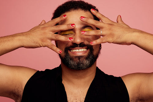Queer wearing nail polish and eye makeup