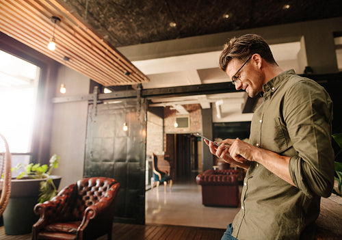Handsome young man reading text message