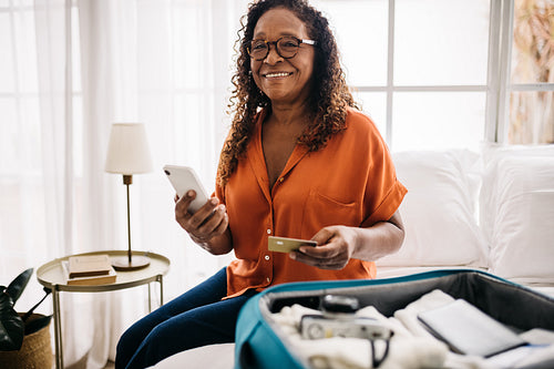 Mature woman shopping travel essential online