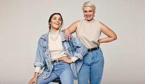 Best friends wearing denim jeans in a studio