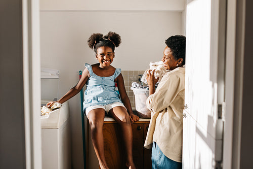 Mother and daughter enjoying time together in laundry room