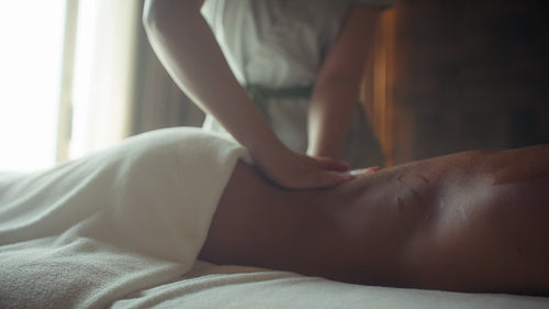 Woman receives a soothing back massage in a serene spa setting promoting relaxation