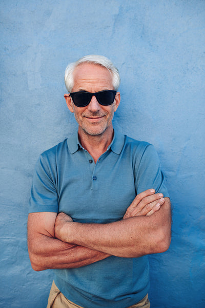 Handsome middle aged male posing against a blue wall