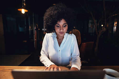 Businesswoman working late on laptop in office