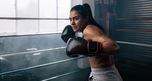 Female boxer training inside a boxing ring